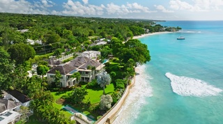 Aerial of Four Winds, a beachfront villa on Gibbs Beach, set in lawned gardens above the turquoise sea in Barbados