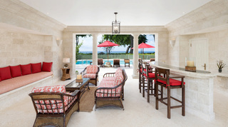 Shaded lounge terrace and coral-stone bar with sea views at Four Winds, a beachfront villa in Barbados
