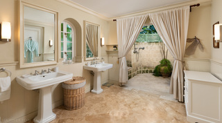 Fustic House bathroom with twin pedestal basins and a curtained opening to a stone-walled outdoor shower, Barbados