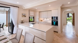 White kitchen with stone island and dining chairs at Garden Wall 13, luxury villa in Barbados