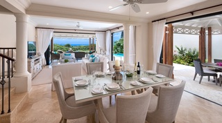 Open-plan dining table beside doors to the terrace and pool at Garden Wall 13 villa, Barbados