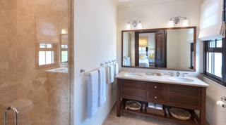 Stone walk-in shower and twin-basin vanity in an ensuite at Garden Wall 13, Apes Hill, Barbados