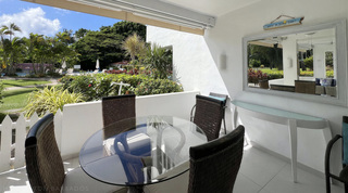 Whitewashed mirror and an island-time sign above the console on the picket-fenced terrace, Glitter Bay 107 in Barbados