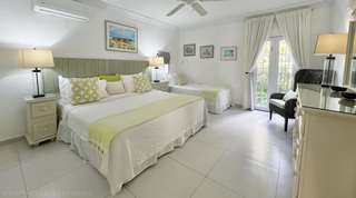 Glitter Bay 107's second bedroom, a king bed and a single bed with lime-green cushions by garden French doors, Barbados