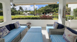Octopus and seahorse cushions on the terrace sofa facing lawns and the pool at Glitter Bay 107, St. James, Barbados