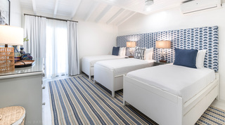Bedroom with two single beds and a blue scallop-pattern headboard at Glitter Bay 204 Sea Men's Inn, Barbados