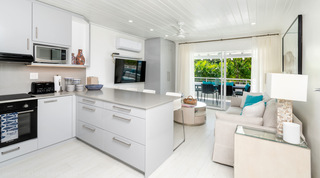 Open-plan kitchen and living room with grey-topped peninsula at Glitter Bay 204 Sea Men's Inn, apartment in Barbados