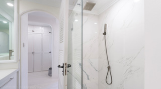 Marble walk-in shower with rainfall head beside the dressing area at Glitter Bay 204 Sea Men's Inn, Barbados