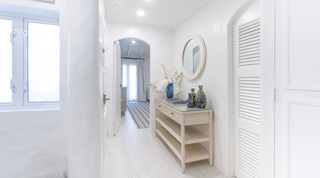 Entrance hallway with a limed-wood console and round mirror at Glitter Bay 204 Sea Men's Inn, Barbados apartment