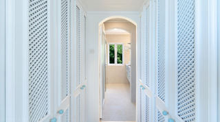 Glitter Bay 301 – The Lighthouse dressing corridor with white lattice wardrobe doors and arched doorway, Barbados