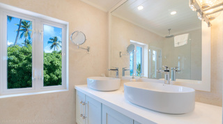 Glitter Bay 301 – The Lighthouse bathroom with twin vessel basins and a window to greenery, St. James, Barbados