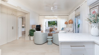 Living room and kitchen counter with sea glimpse through the curtains, Glitter Bay 301 – The Lighthouse, Barbados