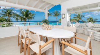 Glitter Bay 301 – The Lighthouse terrace dining table with teak chairs facing the turquoise sea, Barbados