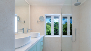 Twin vessel basins on a blue vanity beside a glass shower, Glitter Bay 301 – The Lighthouse, St. James, Barbados