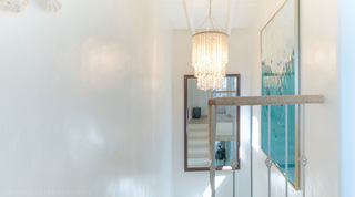 Glitter Bay 301 – The Lighthouse stairwell landing with a beaded chandelier and rope-wrapped balustrade, Barbados