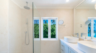 Walk-in glass rain shower beside twin basins at Glitter Bay 301 – The Lighthouse, luxury apartment in Barbados