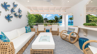 Rattan terrace lounge with coral wall art and sea views beyond the palms, Glitter Bay 302 Bikini Bottom, Barbados