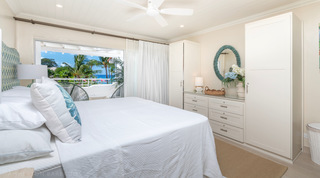 King bedroom with fitted wardrobes and a sea glimpse through the terrace doors, Glitter Bay 302 Bikini Bottom, Barbados