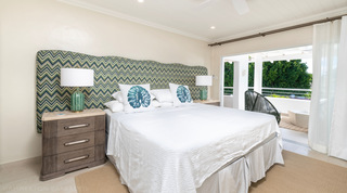 King bedroom with green chevron headboard and terrace doors at Glitter Bay 302 Bikini Bottom apartment, Barbados