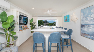 Bar area with blue woven high stools at Glitter Bay 302 – Bikini Top, St. James, Barbados