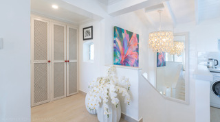 Glitter Bay 302 – Bikini Top landing with ring-shade chandelier and white orchids in Barbados