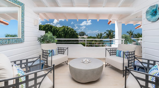 Covered terrace seating with metal armchairs and treetop views at Glitter Bay 302 – Bikini Top, Barbados
