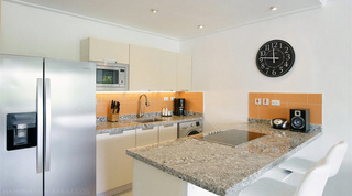 Kitchen with granite worktops, orange tile splashback and breakfast bar stools at Glitter Bay 308, Barbados