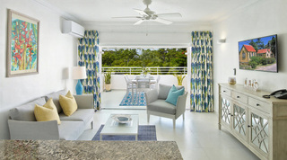 Open-plan living room with grey sofa and mirrored sideboard opening to the terrace at Glitter Bay 308, Barbados