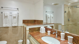 Bathroom with red marble vanity, twin towel rails and walk-in glass shower at Glitter Bay 308, Barbados