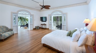Hemingway House Bedroom with king size bed, chair, ceiling fan and doorway to the outside