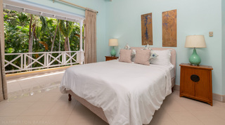 Turquoise bedroom with king bed and twin ceramic lamps at Jamoon, Barbados