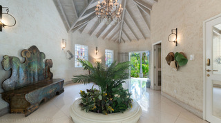 Reception hall with vaulted ceiling, chandelier and a fishtail palm planter at Jamoon villa, Barbados