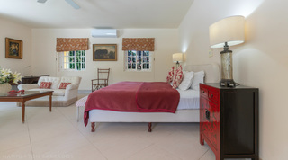 Cream bedroom with king bed, lacquered chest and roman blinds at Jamoon, Sandy Lane, Barbados