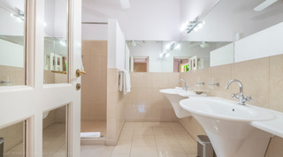 Bathroom with twin pedestal basins and a walk-in shower at Jamoon, Barbados