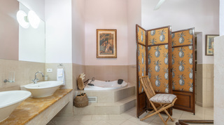 Bathroom with corner whirlpool tub and twin basins at Jamoon villa in Barbados