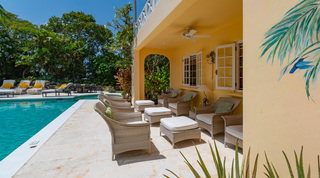 Covered poolside lounge with wicker sofas and tropical murals at Jamoon, Barbados