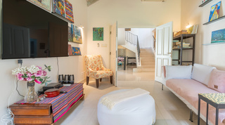 Family room with television and stairway in the cottage wing at Jamoon, Sandy Lane, Barbados