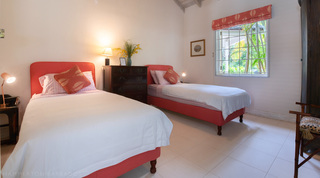 Twin bedroom with two single beds and a garden window at Jamoon villa in Barbados