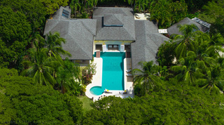 Aerial of the grey-roofed villa and pool set among trees at Jamoon, Sandy Lane, Barbados