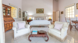 Sitting corner with framed mirror and a window onto palms at Jamoon villa in Barbados