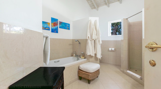 Bathroom with sunken bath, walk-in shower and coastal art at Jamoon villa, Barbados