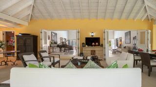 Open living room with baby grand piano and doors to the terrace at Jamoon, Barbados