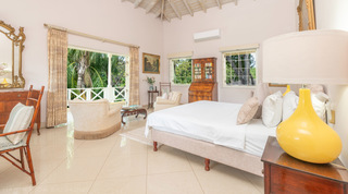 Master suite with king bed and antique bureau bookcase at Jamoon, luxury villa in Sandy Lane, Barbados