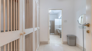 Dressing area with louvred wardrobes and a vanity mirror at Jamoon villa, Barbados