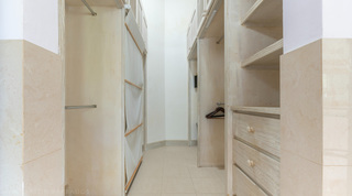 Walk-in wardrobe with fitted shelving and drawers at Jamoon villa in Barbados
