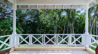 Turquoise bedroom with queen bed and balcony view to garden palms at Jamoon villa, Barbados