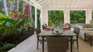 Terrace dining set with red ginger and tropical garden at Jamoon villa, Barbados