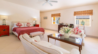 Bedroom with king bed, antique bureau and garden-facing windows at Jamoon, Barbados