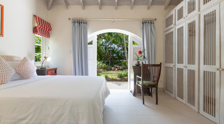 Bedroom with fitted wardrobes and arched doors to the garden at Jamoon, Barbados