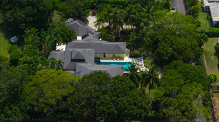 Garden lawn with palms and beds of red ginger at Jamoon villa, Barbados